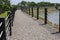 Â Â An pebble walkway fenced with rope along the pond